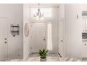 Bright foyer featuring a chandelier, fresh plant, and a clean, inviting entryway with storage hooks at 6156 W Del Rio St, Chandler, AZ 85226