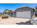 Angle view of a single-story home's two-car garage and desert landscaping, with a white mailbox at 6156 W Del Rio St, Chandler, AZ 85226