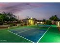 Night view of the private backyard basketball court with lighting and tennis net at 6286 S Reseda St, Gilbert, AZ 85298