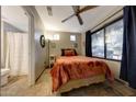 Bright bedroom featuring a large window, ceiling fan and terracotta bedding at 7857 N 21St Ave, Phoenix, AZ 85021