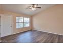 Bright living room featuring wood-look floors, a ceiling fan, and ample natural light at 825 E Michigan Ave, Phoenix, AZ 85022
