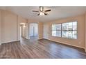 Bright living room featuring wood-look floors, a ceiling fan, and ample natural light at 825 E Michigan Ave, Phoenix, AZ 85022
