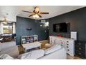 Comfortable living room featuring a ceiling fan, dark accent wall, and white furnishings at 9157 W Gary Rd, Peoria, AZ 85345