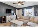 Stylish living room with a ceiling fan, dark wall, modern furniture, and plenty of natural light at 9157 W Gary Rd, Peoria, AZ 85345