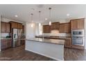 Spacious kitchen with a central island, stainless steel appliances, and wood flooring at 98 N Bay Dr, Gilbert, AZ 85233