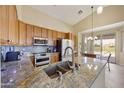 Kitchen with granite countertops, tile backsplash, stainless appliances, and breakfast nook at 992 S Roanoke St, Gilbert, AZ 85296