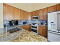 Granite countertop on wood cabinets with stainless appliances and tile backsplash at 992 S Roanoke St, Gilbert, AZ 85296