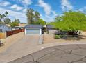 Stunning curb appeal with desert landscaping and a modern gray garage door in this charming home at 10007 N 30Th Pl, Phoenix, AZ 85028
