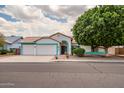 Charming single-story home boasts a three-car garage, desert landscaping and black front door at 10215 W Missouri Ave, Glendale, AZ 85307