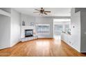Bright living room featuring hardwood floors, fireplace, large windows, and seamless flow to the kitchen at 10215 W Missouri Ave, Glendale, AZ 85307