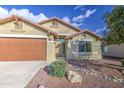 Close-up of a home's facade with a brown garage door and desert landscaping at 10465 E Dutchmans Trl, Gold Canyon, AZ 85118