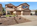 Attractive two-story home boasting a well-manicured front yard, stone accents, and a three-car garage at 10758 E Lobo Ave, Mesa, AZ 85209