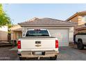 View of the home's front exterior, highlighting the garage and driveway at 11221 W Devonshire Ave, Phoenix, AZ 85037