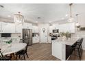 Open kitchen design with white cabinetry, a central island, stainless steel appliances, and stylish light fixtures at 11526 E Shepperd Ave, Mesa, AZ 85212