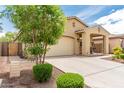 Beautiful exterior featuring a well-manicured lawn, tan stucco and a large driveway leading to a two-car garage at 12357 W Whyman Ave, Avondale, AZ 85323