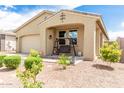 Lovely home with a covered front porch with a bench swing, desert landscaping, and a two-car garage at 12357 W Whyman Ave, Avondale, AZ 85323