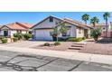 Inviting single-story home featuring a two-car garage, mature trees, and attractive front yard landscaping at 13233 W Mauna Loa Ln, Surprise, AZ 85379