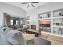 Spacious living room with a vaulted ceiling, a fireplace, and a large sectional sofa at 13233 W Mauna Loa Ln, Surprise, AZ 85379
