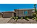 Beautiful single-story home featuring a two-car garage and neatly landscaped front yard under a clear blue sky at 14571 W Wethersfield Rd, Surprise, AZ 85379