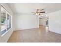 Bright and open living room featuring tile floors, a ceiling fan, and a large window, creating a comfortable space at 1532 W 6Th St, Tempe, AZ 85281