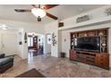 Open living room with tile flooring, a ceiling fan, and an entertainment center at 16461 W Central St, Surprise, AZ 85388