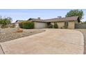 View of the home's wide driveway leading to the garage, complemented by desert landscaping at 1649 W Royal Palm Rd, Phoenix, AZ 85021