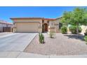 Charming single-story home with a well-manicured lawn, desert landscaping, and a two-car garage at 1761 N Hester Trl, Casa Grande, AZ 85122