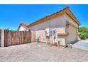 View of side yard with a wood fence, utility access, and gravel ground cover at 1761 N Hester Trl, Casa Grande, AZ 85122