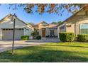 Welcoming home with a lovely front patio, relaxing fountain, and beautifully landscaped yard under a clear blue sky at 2045 E San Carlos Pl, Chandler, AZ 85249
