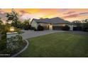 Wide driveway leads to this home's three-car garage, surrounded by green grass and vibrant shrubbery at 20644 E Sunrise Ct, Queen Creek, AZ 85142