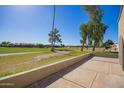 Relaxing back patio overlooking the golf course, mature trees, and lush green landscaping at 2211 N Recker Rd, Mesa, AZ 85215