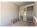 Inviting front porch with a rustic bench, potted plant, welcome sign, and a well-maintained entrance at 23179 S 225Th Pl, Queen Creek, AZ 85142