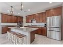 Well-equipped kitchen boasts granite countertops, wooden cabinets, stainless steel appliances, and a breakfast bar at 23179 S 225Th Pl, Queen Creek, AZ 85142