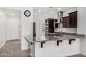 Bright and modern kitchen with granite countertops, stainless steel appliances, breakfast bar, and dark wood cabinetry at 2368 E Bellerive Dr, Gilbert, AZ 85298