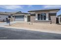 Gorgeous one-story home featuring a brick facade, a large garage, and drought-resistant landscaping in a desirable community at 24000 S 218Th Pl, Queen Creek, AZ 85142