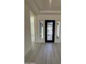 Bright foyer with light wood flooring and a decorative black front door at 24000 S 218Th Pl, Queen Creek, AZ 85142