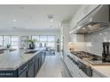 Bright open kitchen with white cabinets, stainless steel appliances, and an island with marble countertop at 24000 S 218Th Pl, Queen Creek, AZ 85142
