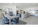 A stylish kitchen with dining area features modern appliances, an island with bar seating, and sleek countertops at 24000 S 218Th Pl, Queen Creek, AZ 85142