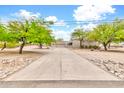 Charming stucco home featuring a spacious driveway and an attached two-car garage with decorative wood beam accents at 27347 N Gary Rd, San Tan Valley, AZ 85144