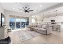 Bright living room boasts a large sectional sofa, neutral colors, and seamless access to the outdoor space at 32582 N Durango Ln, San Tan Valley, AZ 85143