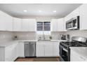 Stylish kitchen with white cabinets, stainless steel appliances and a window above the sink at 4137 E Sells Dr, Phoenix, AZ 85018