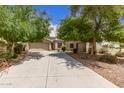 Inviting single-story home with a spacious driveway and mature trees at 41804 W Carlisle Ln, Maricopa, AZ 85138
