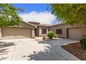 Well-maintained single-story home featuring a two-car garage and desert landscaping at 41804 W Carlisle Ln, Maricopa, AZ 85138