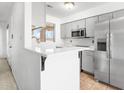 Bright kitchen featuring gray cabinets, stainless appliances, and a breakfast bar at 420 W Yukon Dr # 4, Phoenix, AZ 85027