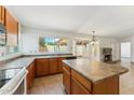 Well-lit kitchen featuring an island, wood cabinets, and a large window offering backyard views at 4202 E Brookwood Ct, Phoenix, AZ 85048