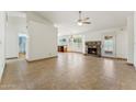 Bright living room featuring tile flooring, a stone fireplace, and seamless flow to the adjacent kitchen at 4202 E Brookwood Ct, Phoenix, AZ 85048