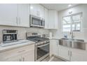 Bright kitchen features stainless steel appliances, white cabinetry, and a subway tile backsplash at 4240 E Bluefield Ave, Phoenix, AZ 85032