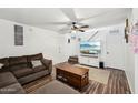 Cozy living room featuring new flooring, a ceiling fan, and a entertainment area at 5923 W Townley Ave, Glendale, AZ 85302