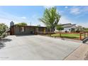 Home exterior with a wide driveway, well-kept lawn and trees in the yard at 6814 N 14Th St, Phoenix, AZ 85014