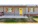 Charming home featuring a bright yellow front door, decorative shutters, and a covered front patio for welcoming guests at 6814 N 14Th St, Phoenix, AZ 85014